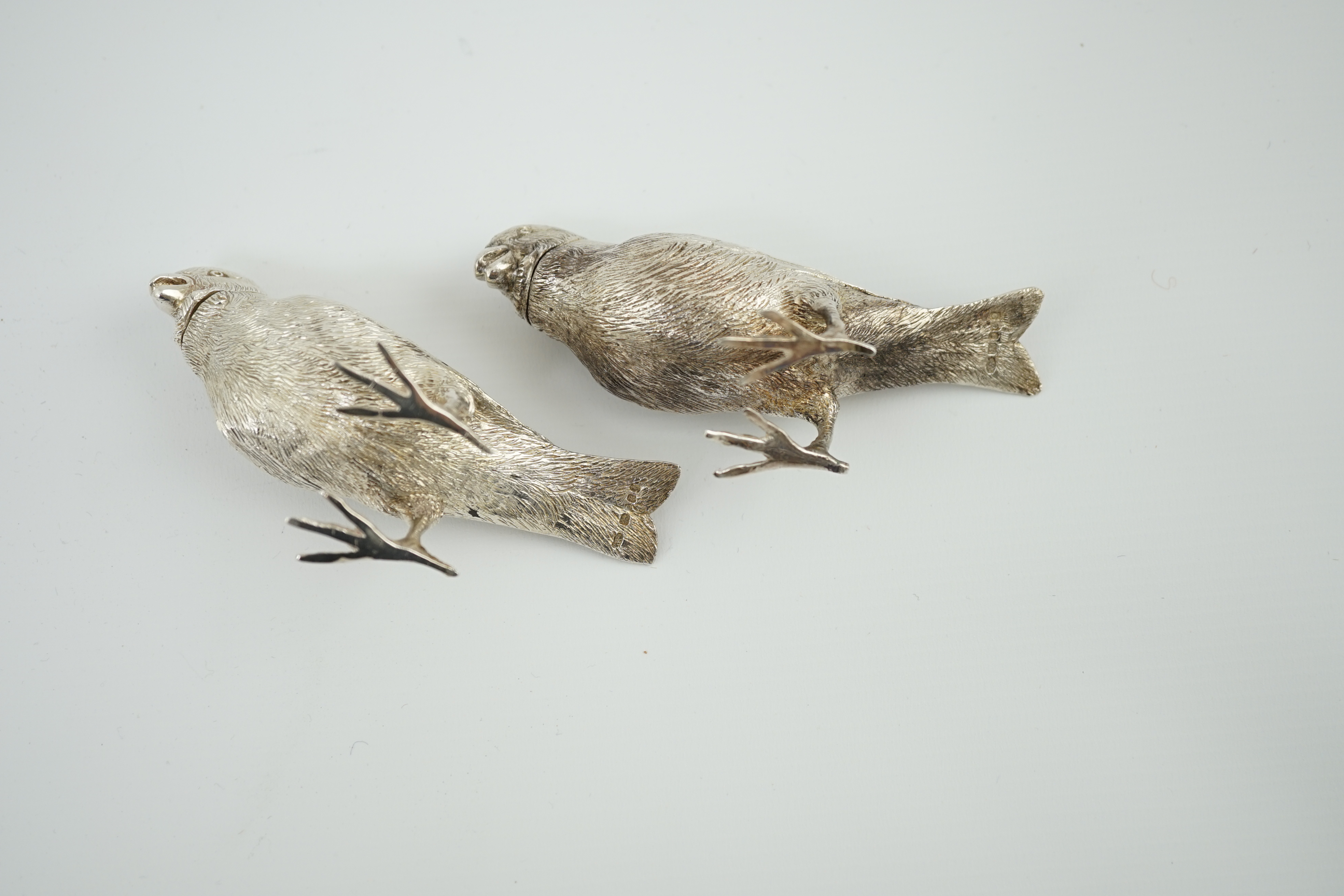 A pair of Elizabeth II silver novelty free-standing pepperettes, modelled as sparrows, by Israel Freeman & Son Ltd